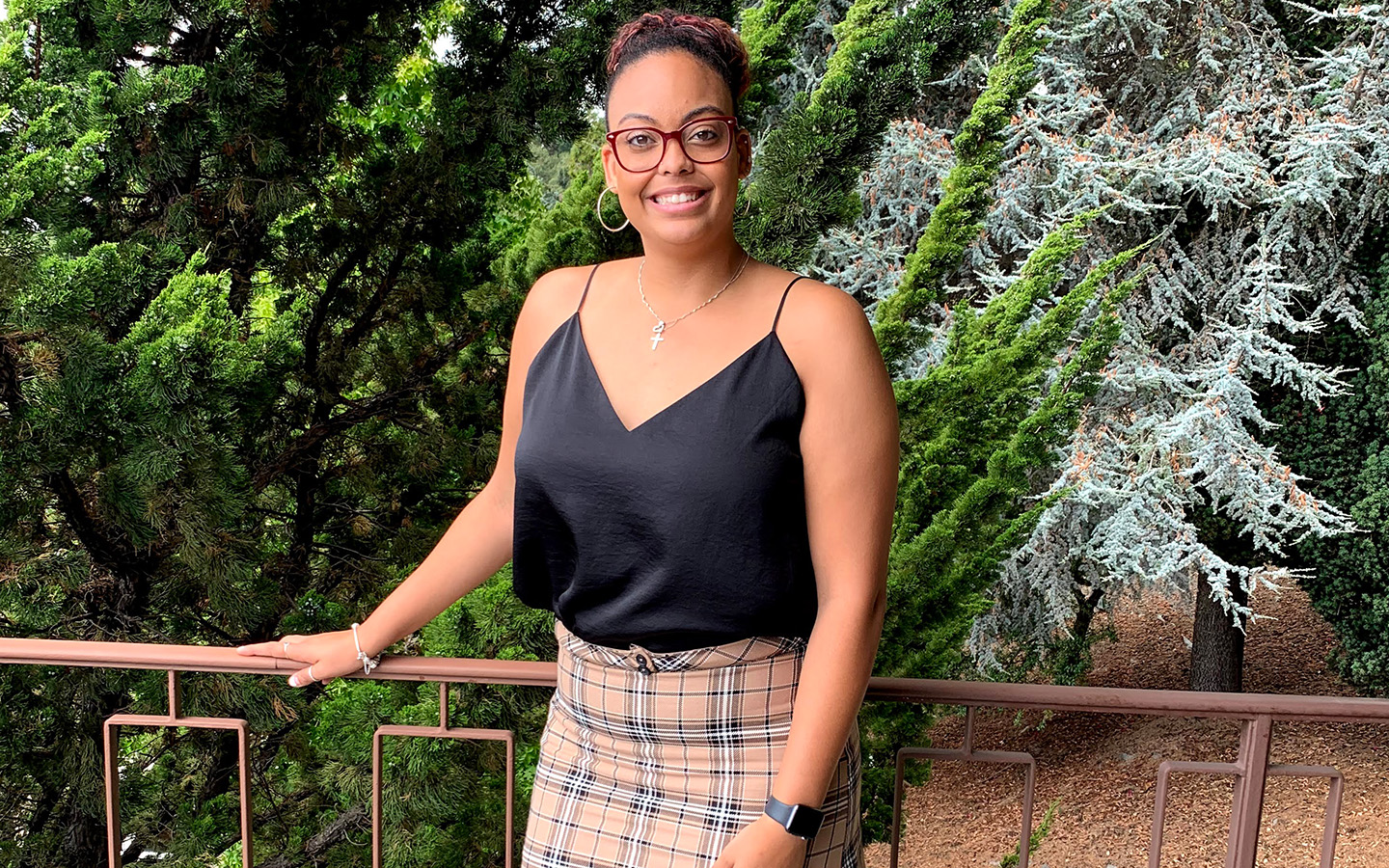 HNU 2020 graduate Chelyn Williams in front of foliage